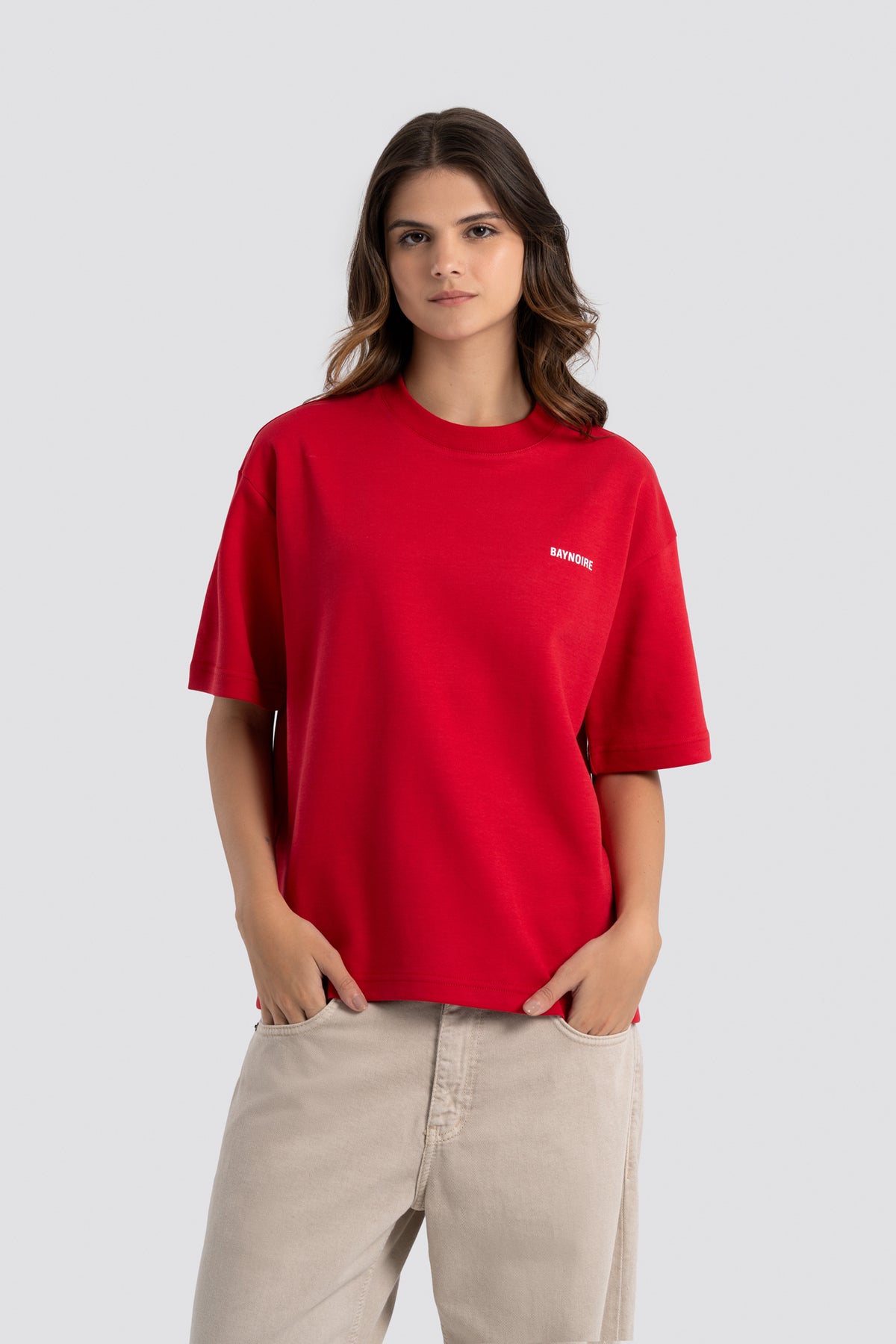 Person wearing a red t-shirt with a logo on a white background