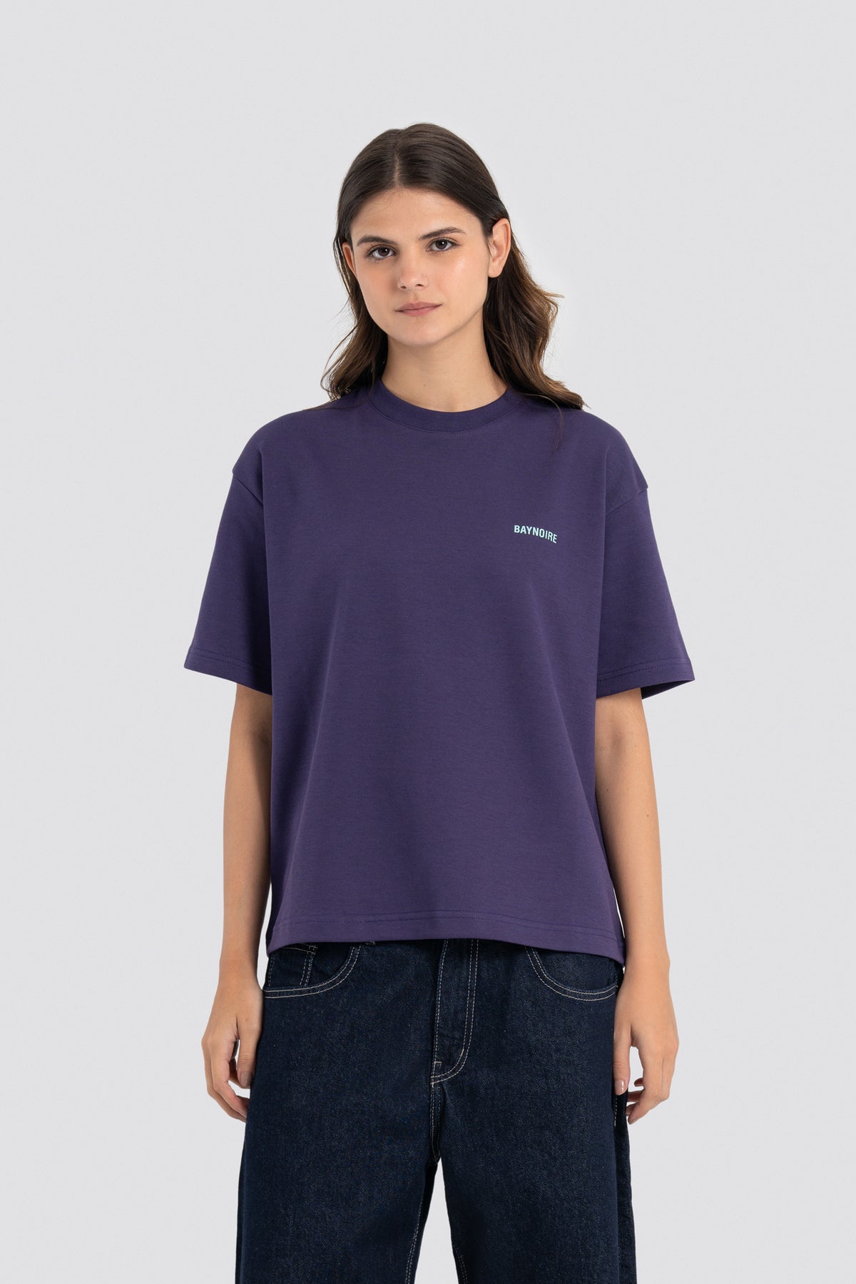 Person wearing a purple t-shirt with a logo on a white background