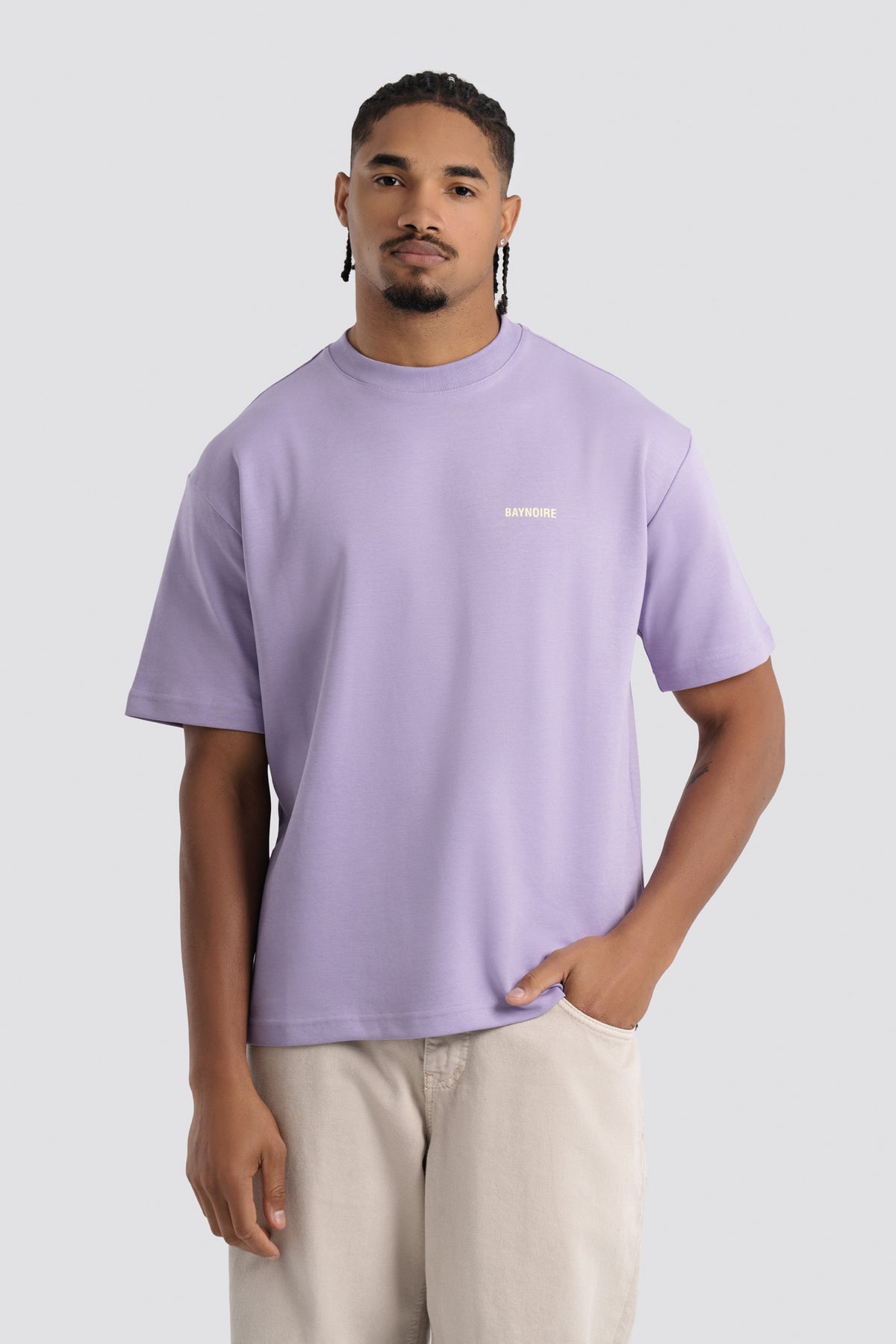 Man wearing a light purple t-shirt with a logo on a white background