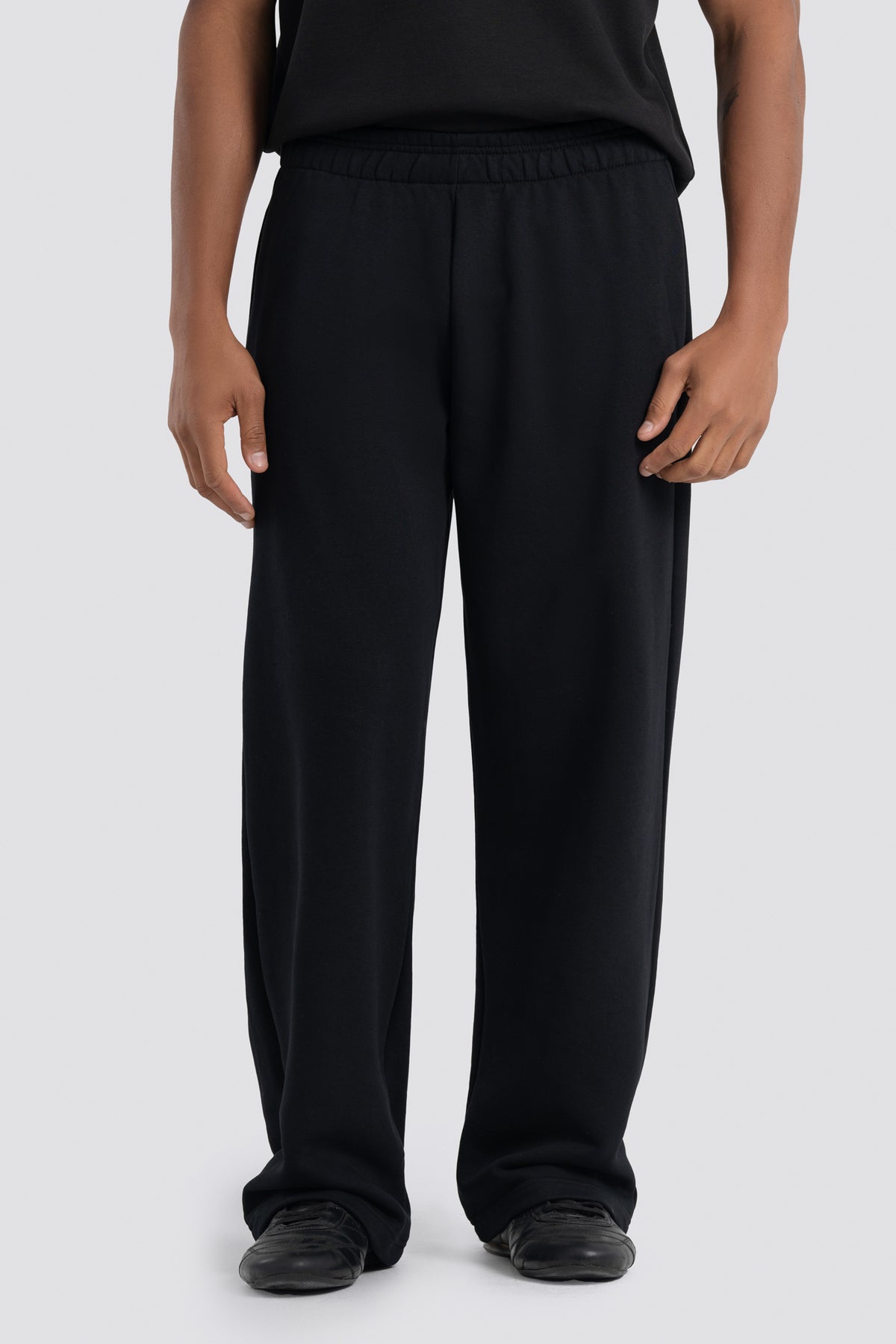 Person wearing black pants on a white background