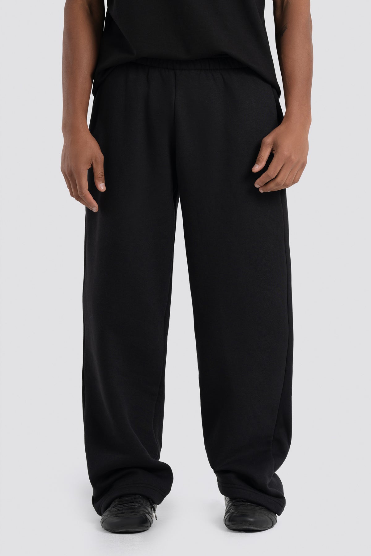 Person wearing black pants on a white background