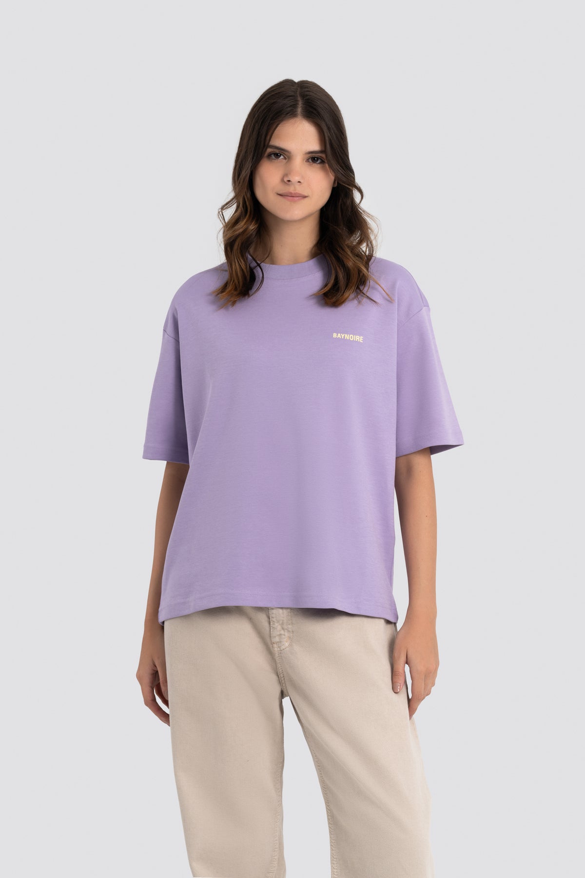 Woman wearing a purple t-shirt with a logo on a white background