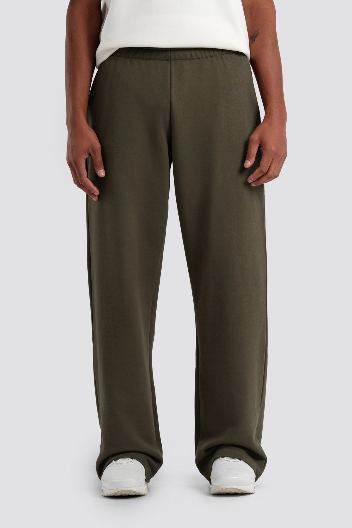 Person wearing olive green pants on a white background