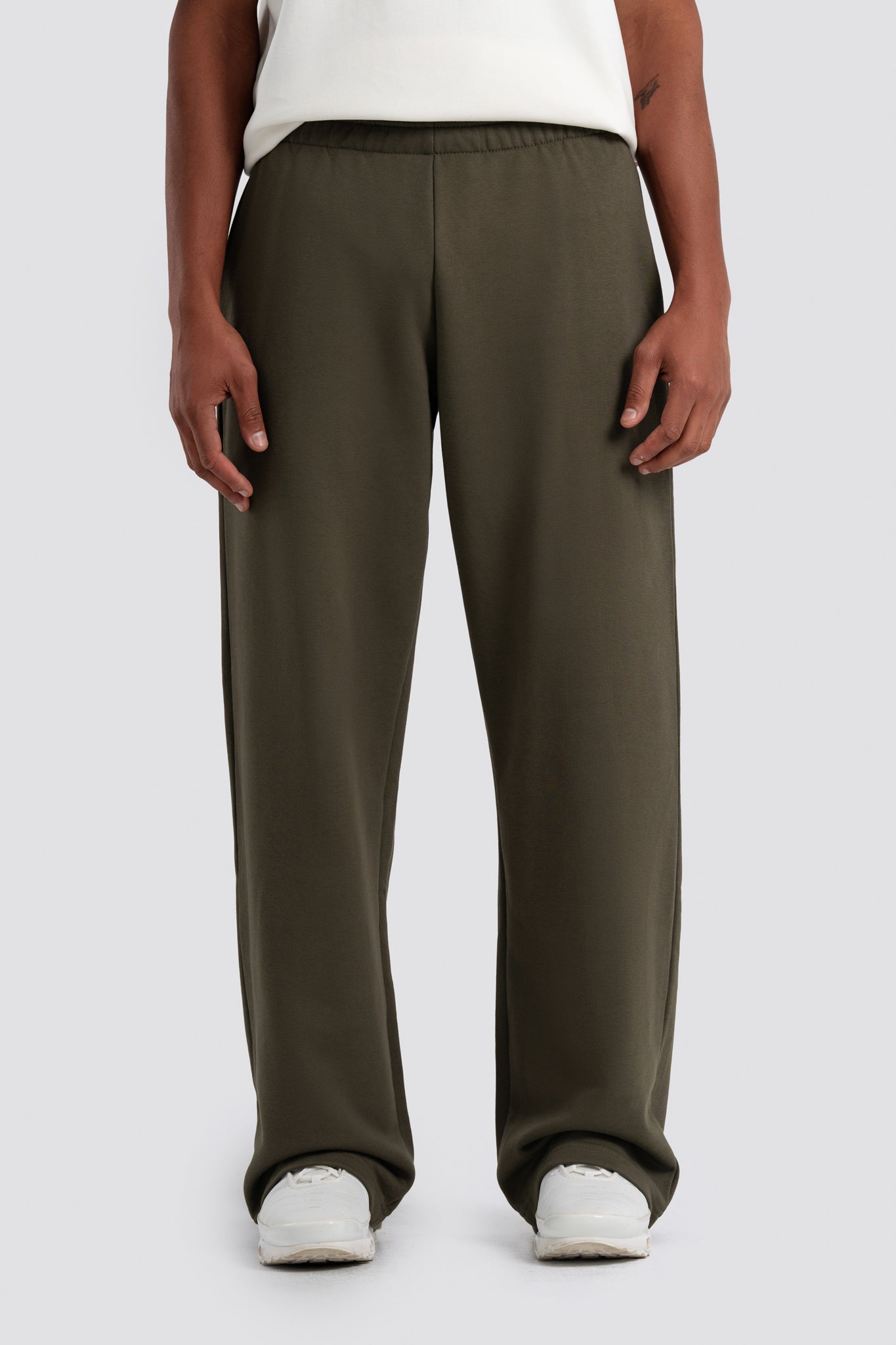 Person wearing olive green pants on a white background