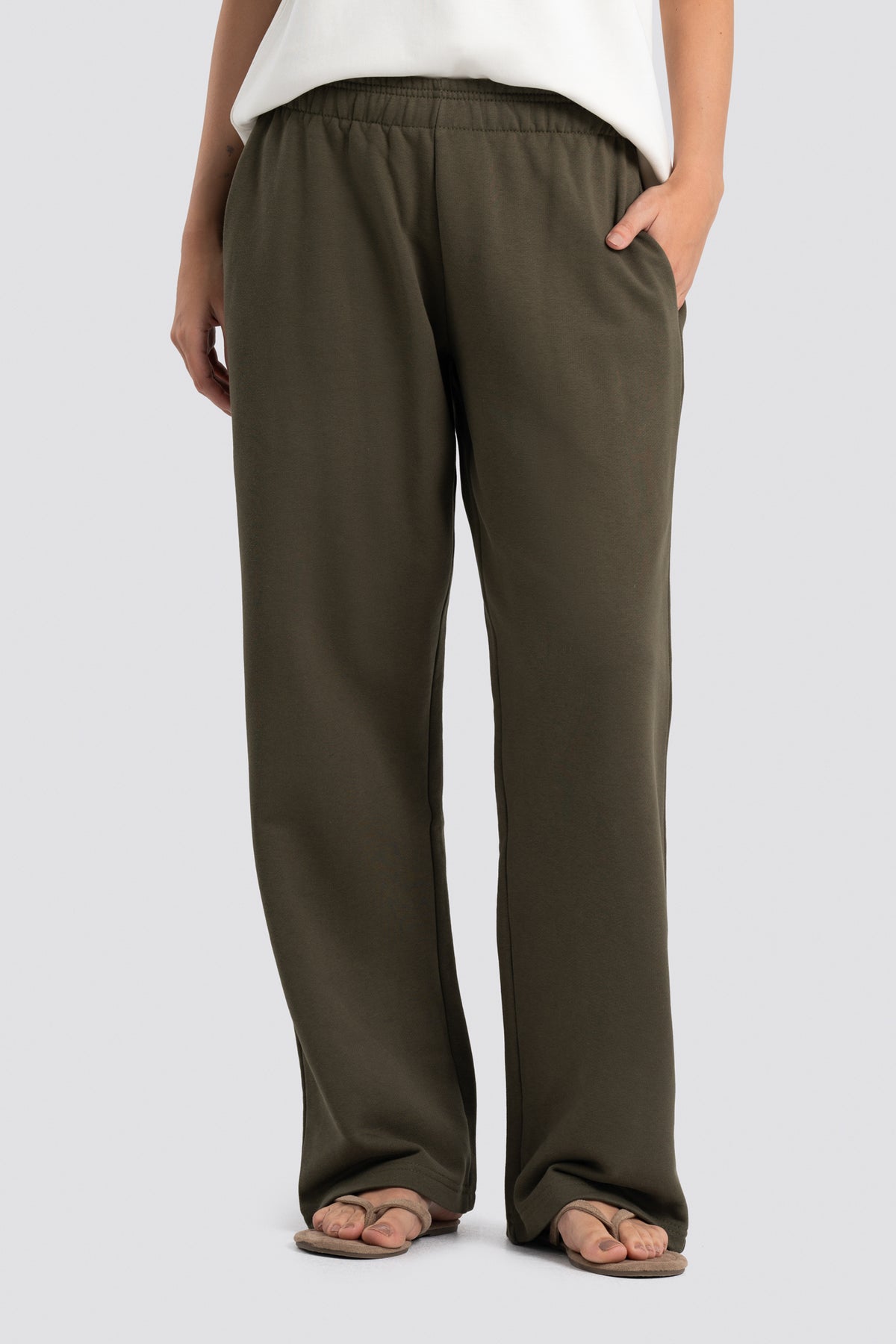 Olive green pants worn by a person on a white background