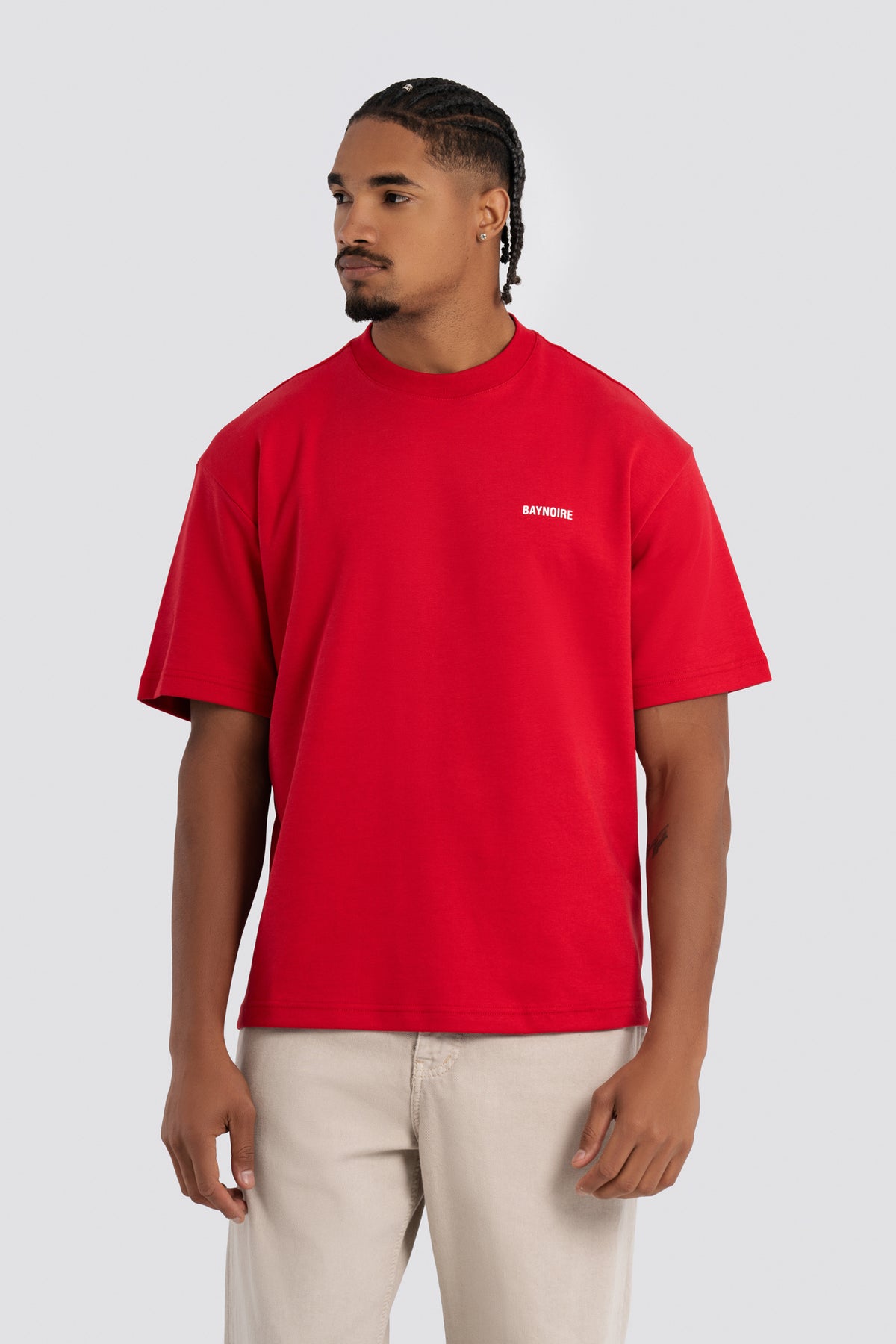 Man wearing a red t-shirt with a logo on a white background
