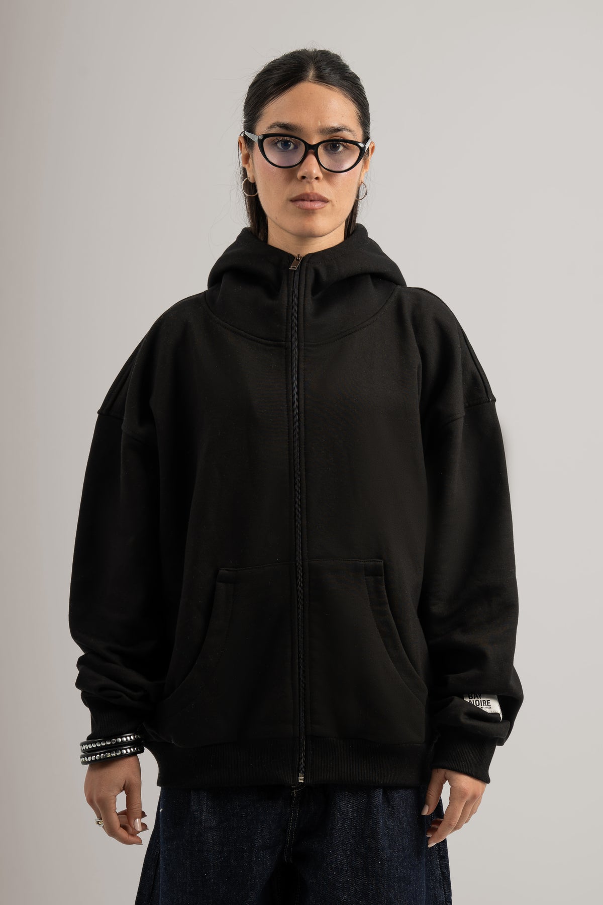 Person wearing a black hoodie on a plain background